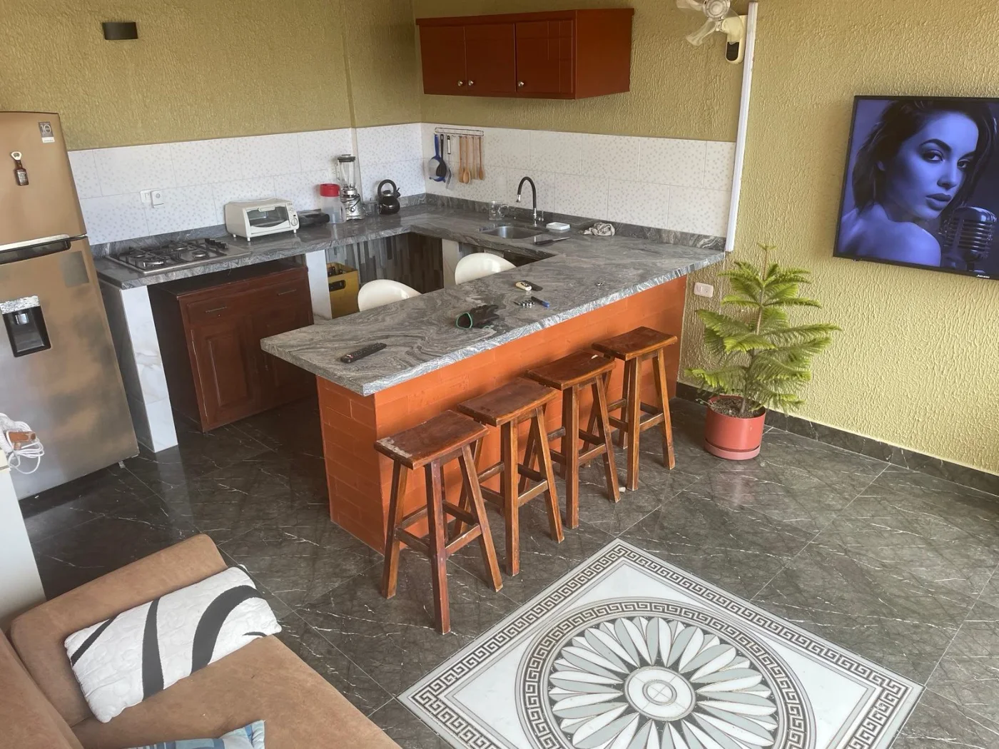 La cocina, con la barra y los taburetes