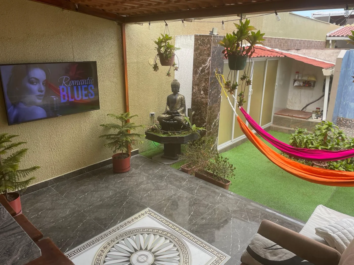 El patio, con las hamacas y el buda
