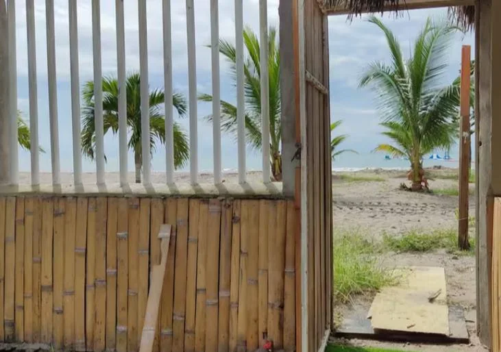 El portón de caña abierto a la playa